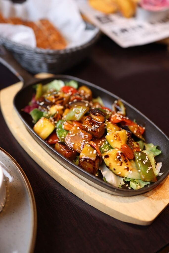 HOME Vibrant Asian stir fry with vegetables and sauce in a skillet, perfect for food enthusiasts.